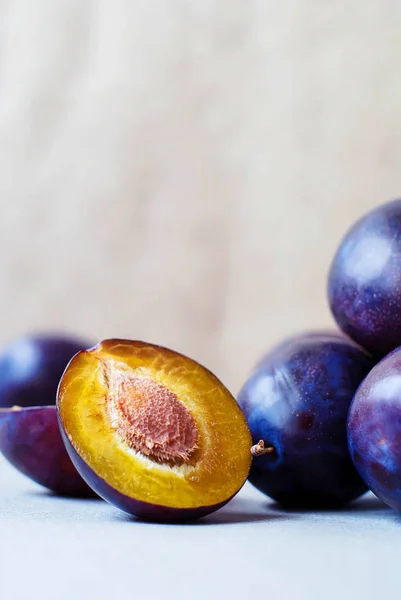 Dark blue plums on a light background. — Stock Photo, Image