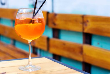 aperol spritz ahşap bir masaya kokteyl bardak