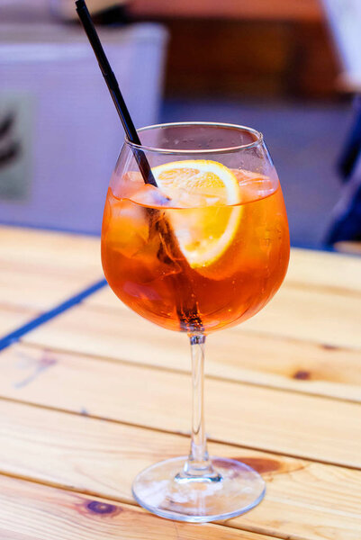 glass of aperol spritz cocktail on a wooden table