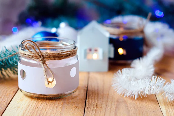 Velas de Año Nuevo con decoraciones de árboles de Navidad y una casa de candelabros blancos. y ramas de árbol de Navidad con una guirnalda de Navidad — Foto de Stock