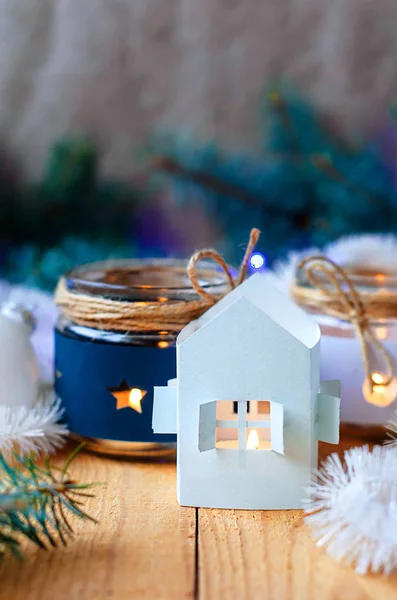 Velas de Año Nuevo con decoraciones de árboles de Navidad y una casa de candelabros blancos. y ramas de árbol de Navidad con una guirnalda de Navidad —  Fotos de Stock