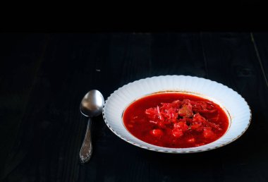 Siyah bir arka plan beyaz bir tabak içinde Ukrayna pancar çorbası