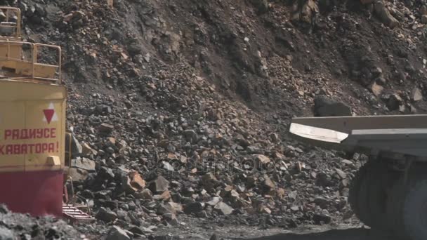 Belarús, Mikhashevichy: junio, 2016: excavadora carga una piedra en el camión pesado Belaz en la cantera de granito minero — Vídeo de stock