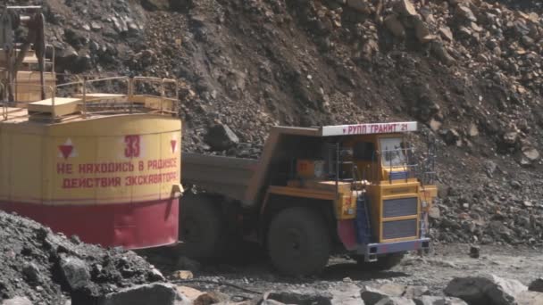 Valko-Venäjä, Mikhashevichy: kesäkuu, 2016: kaivinkone lataa kiven raskaaseen kuorma-autoon Belaz louhoksessa graniitti — kuvapankkivideo