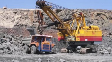 Beyaz Rusya, Mikhashevichy: Haziran, 2016: Ekskavatör bir taş ocağı incelemesi granit ağır kamyon Belaz yükler