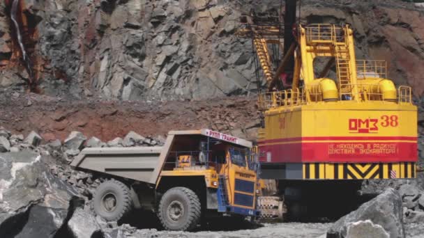 Weißrussland, Mikhaschewitschi: Juni 2016: Bagger belädt einen Stein im schweren Lastwagenbelaz im Steinbruch, der Granit abbaut — Stockvideo