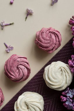 Pembe ve beyaz marshmallow Eflatun çiçekler bir masada. Tatlı