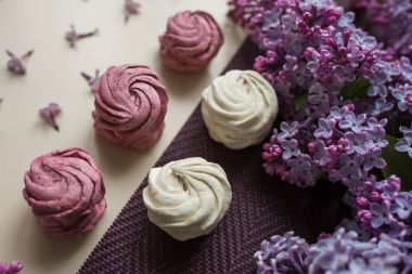 Pembe ve beyaz marshmallow Eflatun çiçekler bir masada. Tatlı