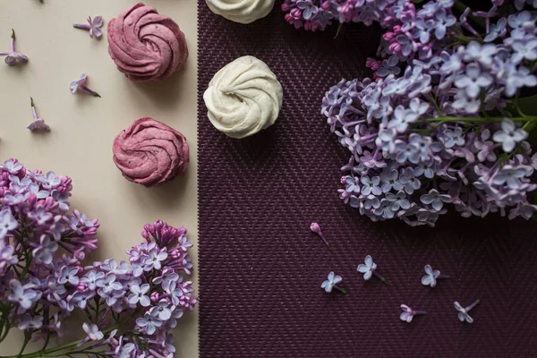 Guimauves roses et blanches sur une table aux fleurs lilas. Doux — Photo