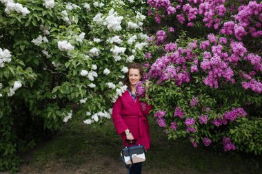 Kadın bir leylak pembe çiçekler ağaç bahar bahçe çevresinde