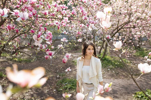 Beauty woman standing on Magnolia blossoming flowers background. — Stock Photo, Image