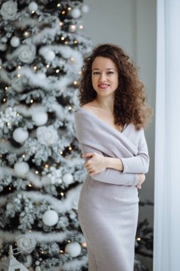 Bir Noel tre arka plan üzerinde bir gülümseme ile güzel kız