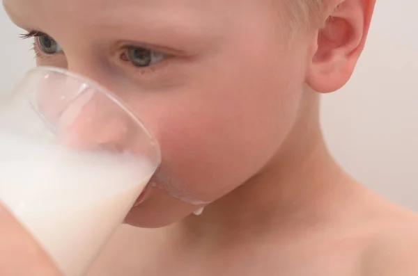 El niño bebe leche de un vaso para el desayuno. . —  Fotos de Stock