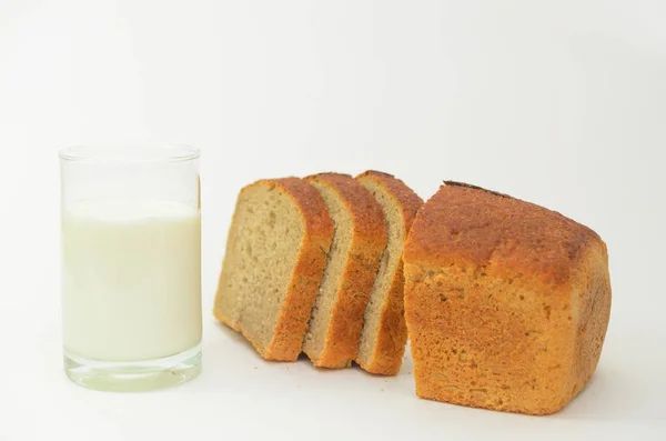 Milk in a glass on a light background with fresh crusted bread. — Stock Photo, Image