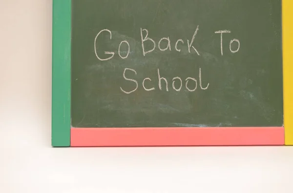 School supplies on a background of a school board with an inscription and on a light background. — Stock Photo, Image