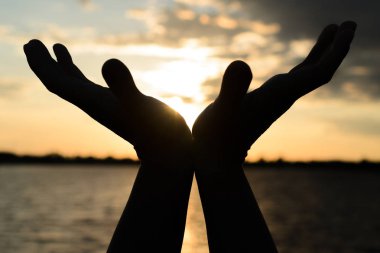 Günbatımı yaz akşam göl üzerinde avuç içi.