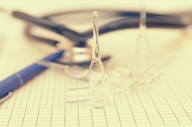 Bir ilaç ile doktor Resepsiyon bir kalem, hastalık ve ampul geçmişi ile birlikte bir phonendoscope yatıyor.