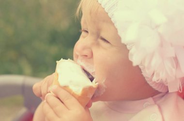 Küçük bir kız dondurma yiyor ve onun yüzüne bulaşmış