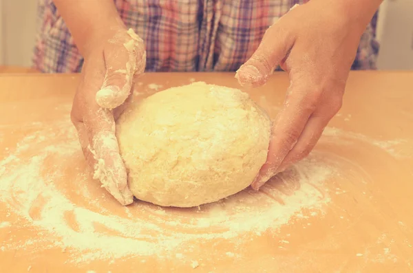 Eine Frau knetet einen selbstgemachten Teig für die Pizzaproduktion. — Stockfoto