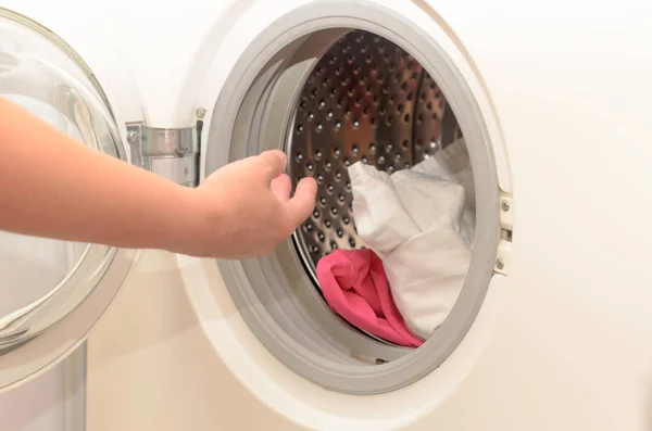 Washing dirty clothes in an automatic washing machine.