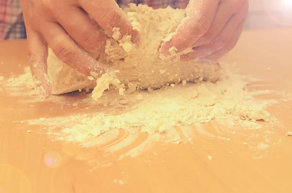 Uma mulher amassa uma massa caseira para a produção de pizza . — Fotografia de Stock