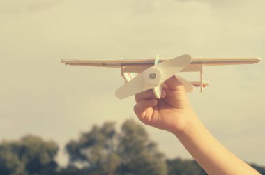 Çocuk elini modeli uçağın gökyüzüne doğru çalışır..