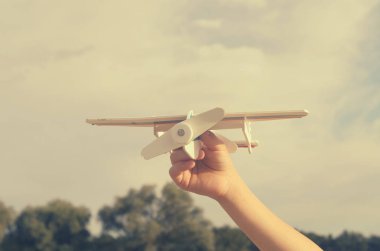 Çocuk elini modeli uçağın gökyüzüne doğru çalışır..
