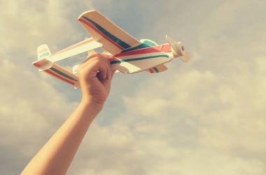 Çocuk elini modeli uçağın gökyüzüne doğru çalışır..