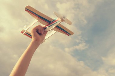Çocuk elini modeli uçağın gökyüzüne doğru çalışır..