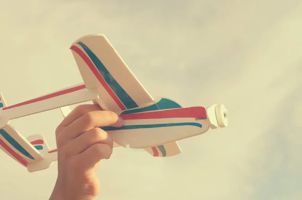 Der Junge lässt mit der Hand das Modell des Flugzeugs in den Himmel steigen. — Stockfoto