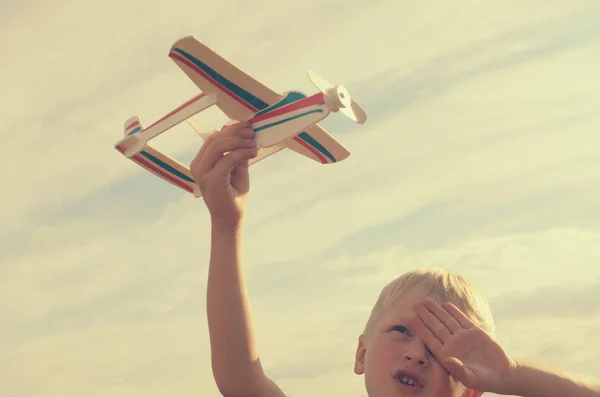 Pojken med sin hand rinner modell av planet i himlen. — Stockfoto