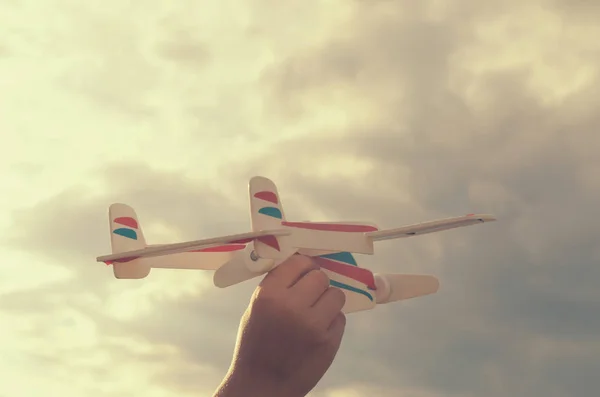 Gutten med hånden kjører modellen av flyet opp i himmelen. . – stockfoto