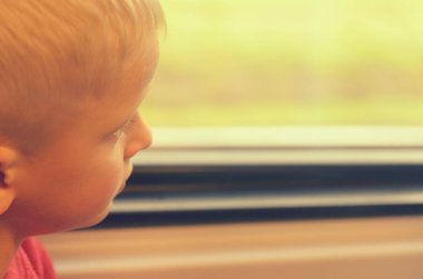 Çocuk tren vagonuna pencereden görünüyor.