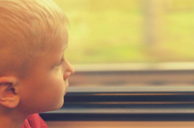 Çocuk tren vagonuna pencereden görünüyor.
