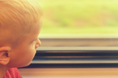 Çocuk tren vagonuna pencereden görünüyor.