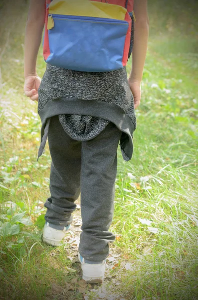 Мальчик идет в поход в кроссовках и рюкзаке за плечами . — стоковое фото