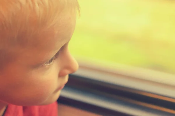 Pojken ser ut genom fönstret på tåget bilen. — Stockfoto