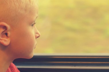 Çocuk tren vagonuna pencereden görünüyor.