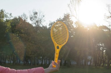 Elinde bir tenis raketi topu hareket halinde yakalar..