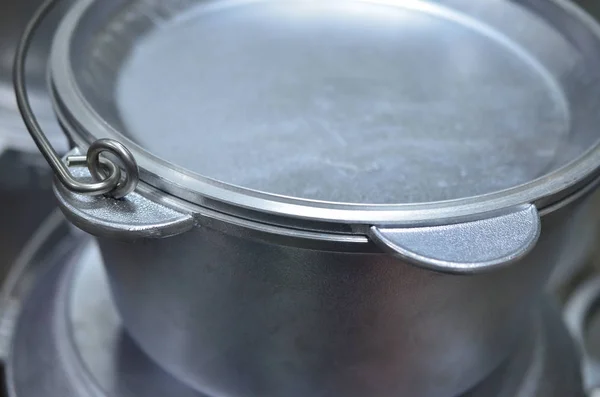 Metal saucepan with a lid for cooking on fire.