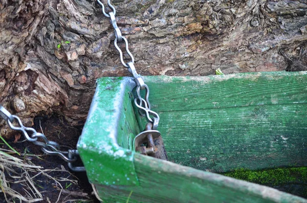 La vecchia barca è legata a un tronco d'albero da una catena . — Foto Stock
