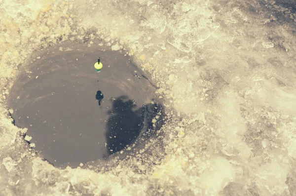 Round ice in the ice with a float on the line.