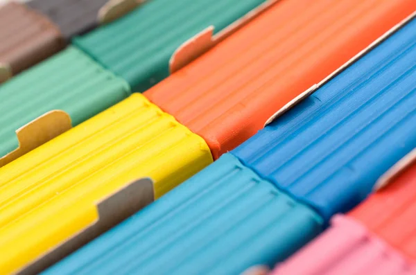 Uma caixa com uma plasticina multicolorida de forma alongada . — Fotografia de Stock