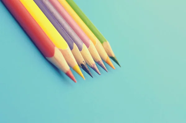 Grupo de lápis de chão colorido em um fundo azul . — Fotografia de Stock