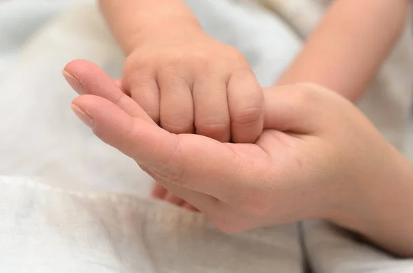 Рука ребенка держит маму за палец . — стоковое фото