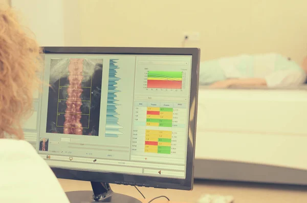 Bir kadın x-ray Dansitometresi sonuçlarını inceler.