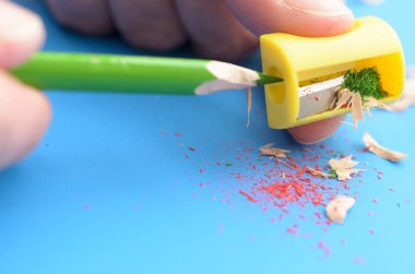 Bir kalemtıraş ile renkli kalemler keskinleştirme.