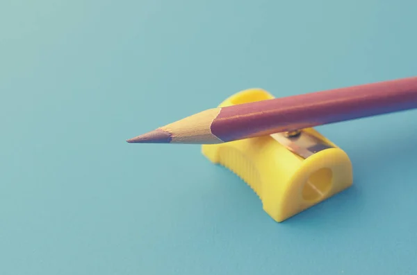 Afie os lápis coloridos com um apontador . — Fotografia de Stock
