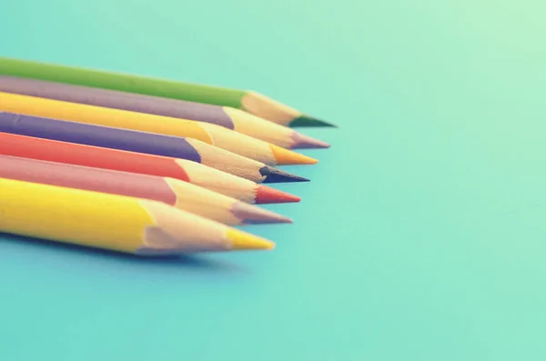 Grupo de lápis de chão colorido em um fundo azul . — Fotografia de Stock