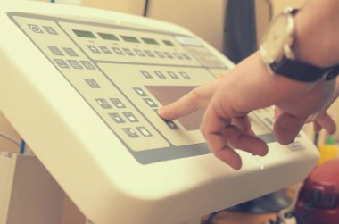 Radyolog presler düğmesine bir X-ray görüntü üretmek için kontrol panelinin.